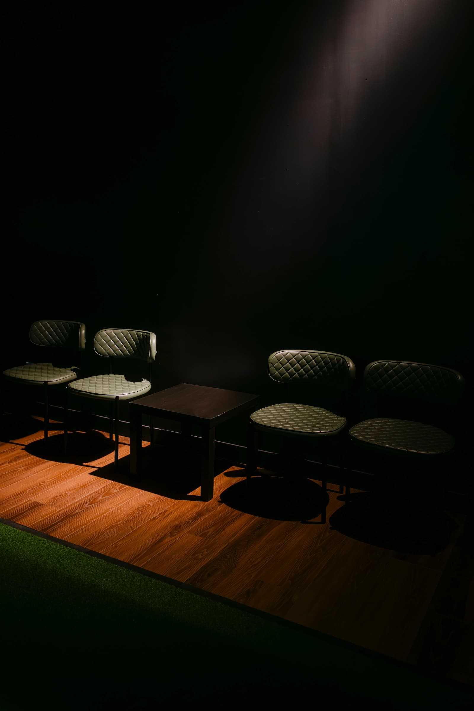 Seating area for players and guests inside Forged Golf simulator bay